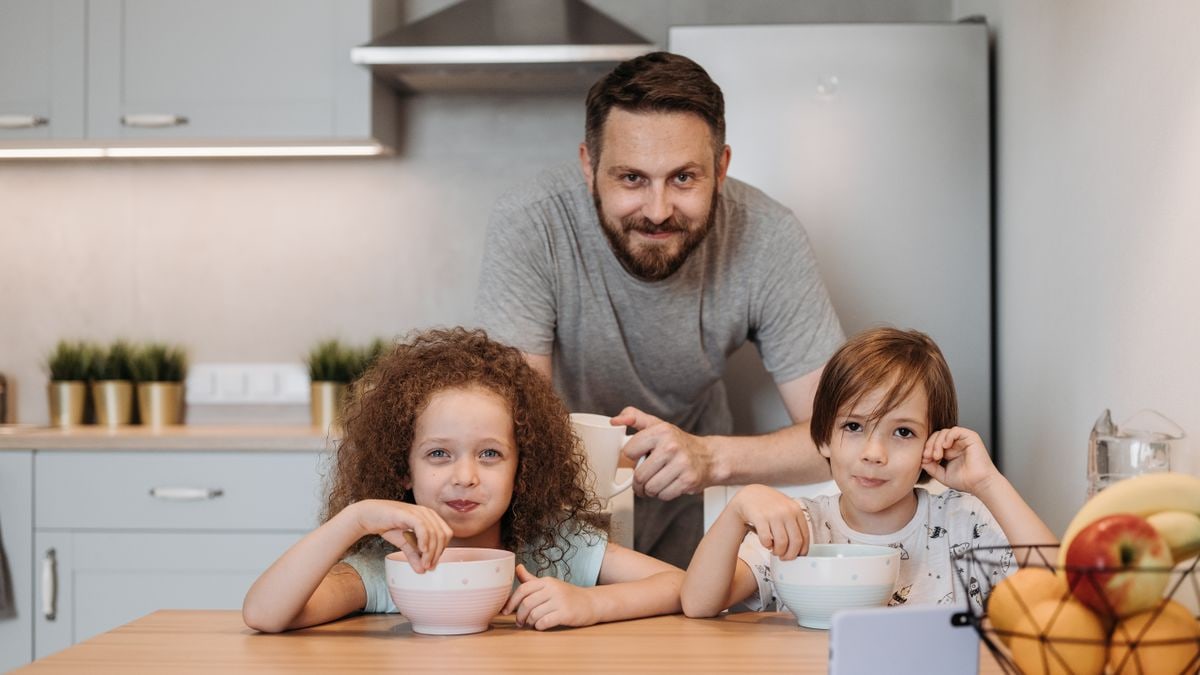Father and children enjoying breakfast together in a cozy kitchen setting.